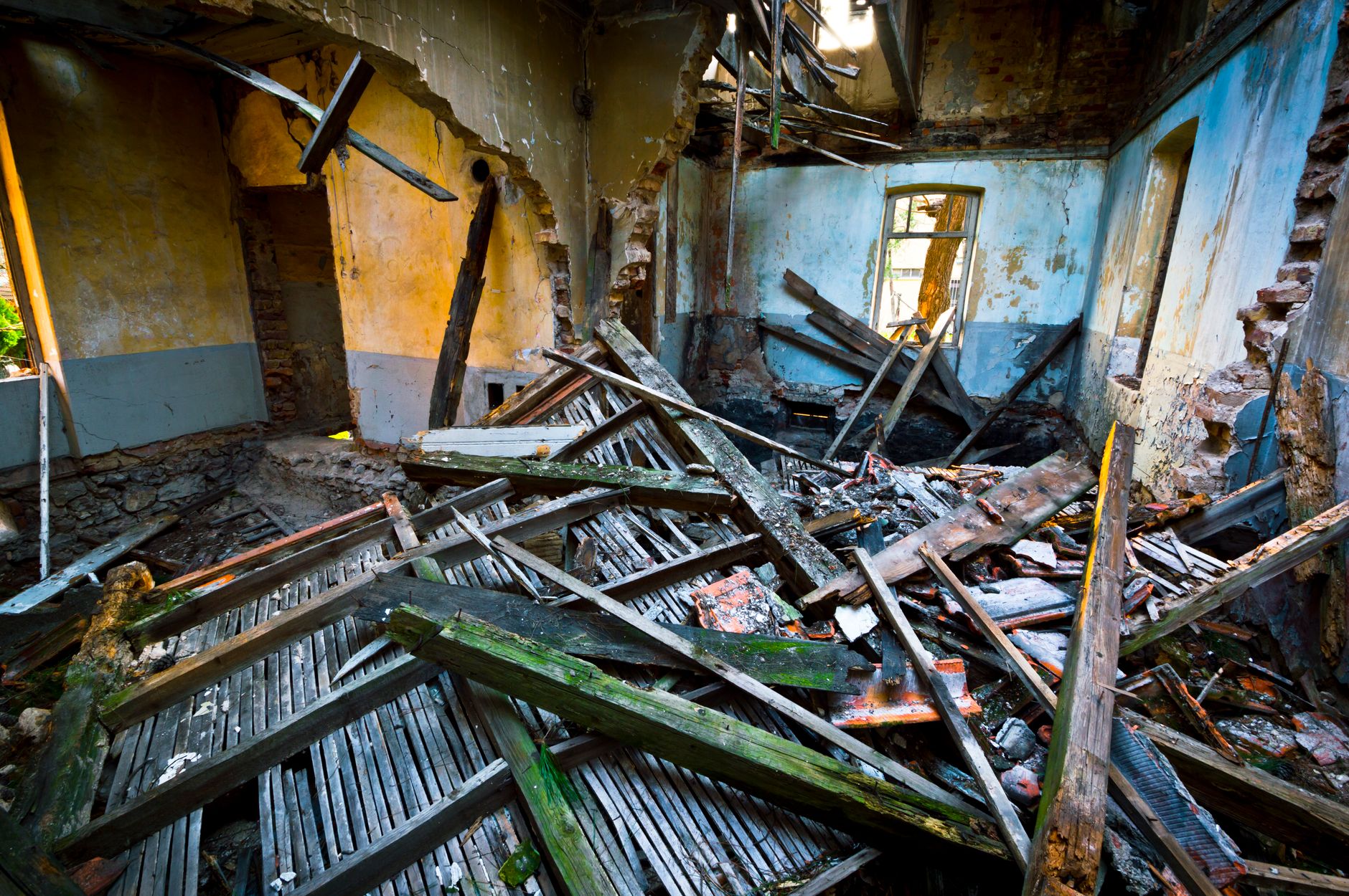 Storm-damaged interior with collapsed beams and debris