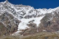 Majestic view of snow-covered mountains in Breuil-Cervinia, Italy under a clear blue sky.