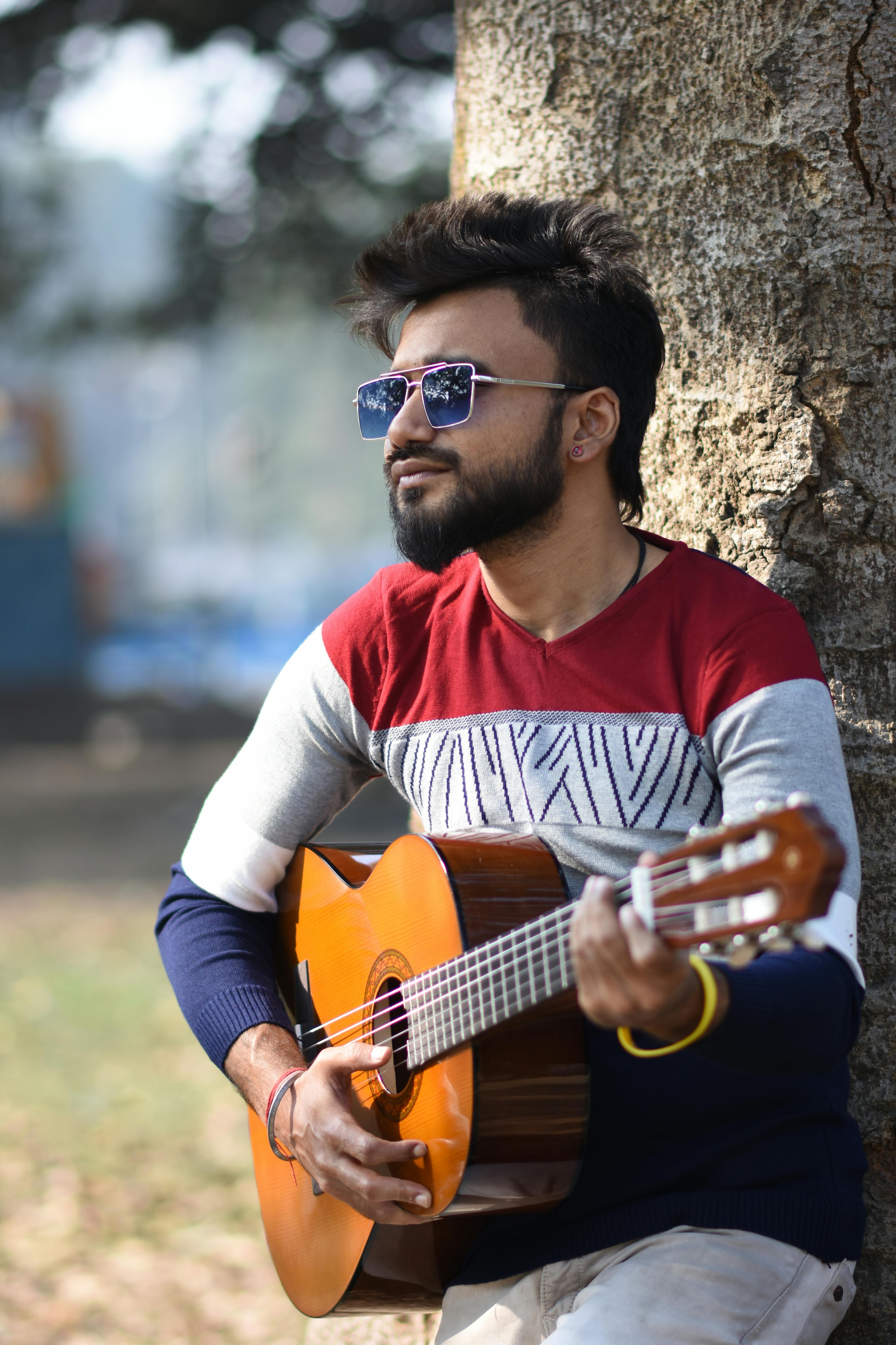 Gratis Un elegante guitarrista toca la guitarra acústica al aire libre en Calcuta, India. Foto de stock