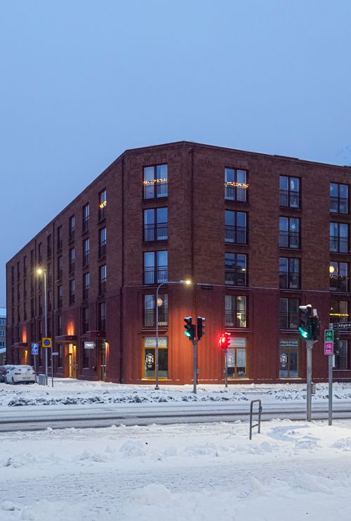 Free A snowy evening in Jönköping, Sweden, featuring a brick residential building. Stock Photo