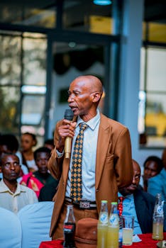 Elderly man giving a speech in a formal setting indoors.