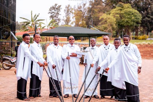 Group of men in traditional attire posing outdoors, showcasing cultural fashion.