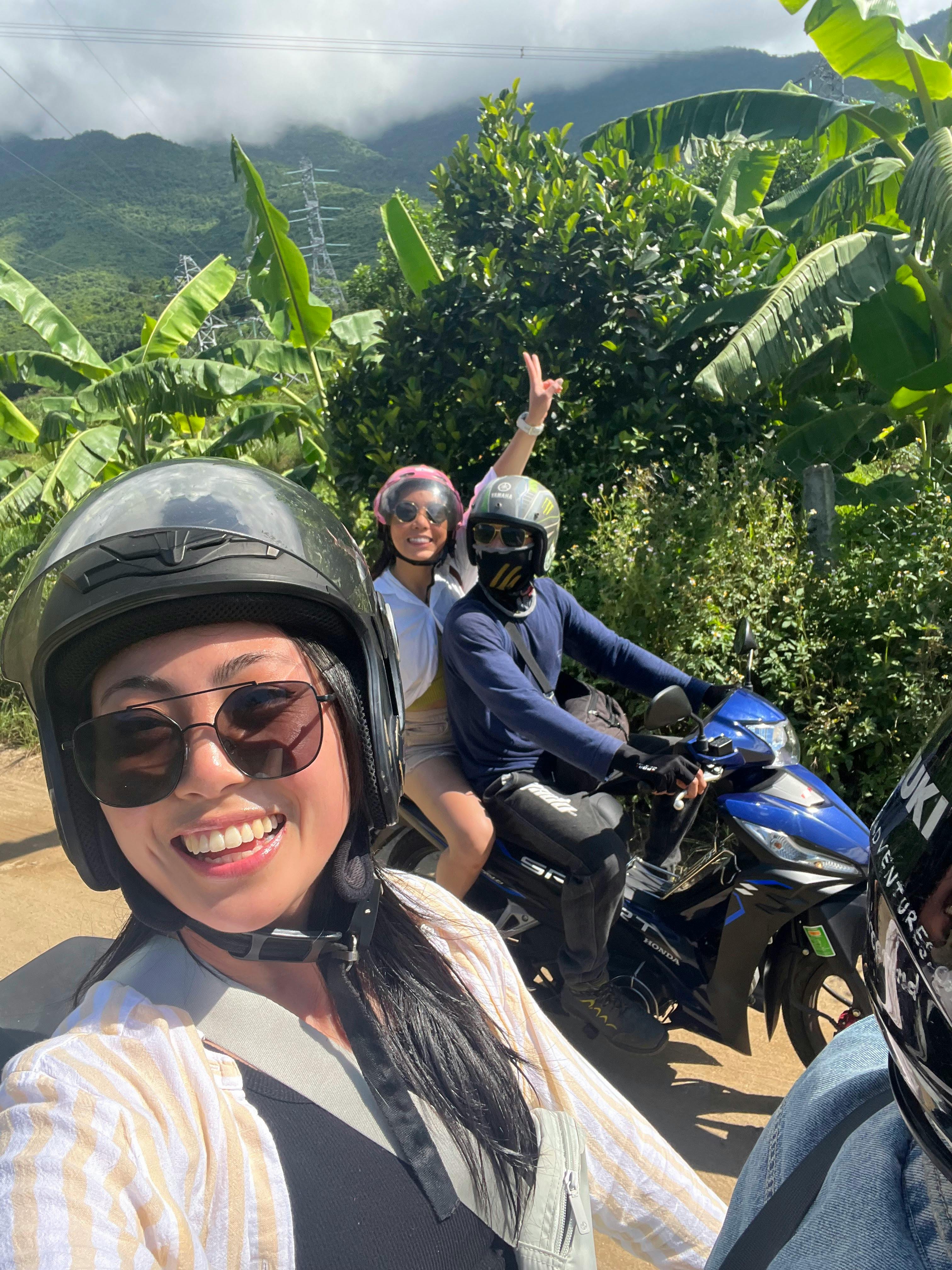 Gratis Tre venner koser seg på en solrik motorsykkeltur utendørs, omgitt av frodig grøntområde. Arkivbilde