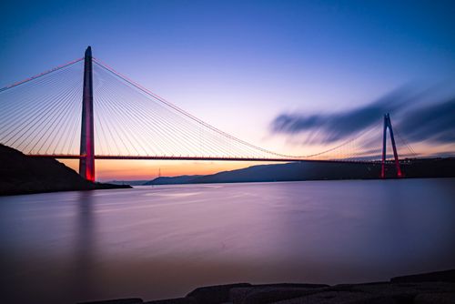 Free Long exposure of a bridge at twilight over calm waters, showcasing vibrant colors. Stock Photo