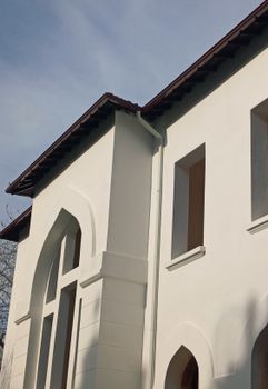 Architectural detail of a modern white building with arched windows.
