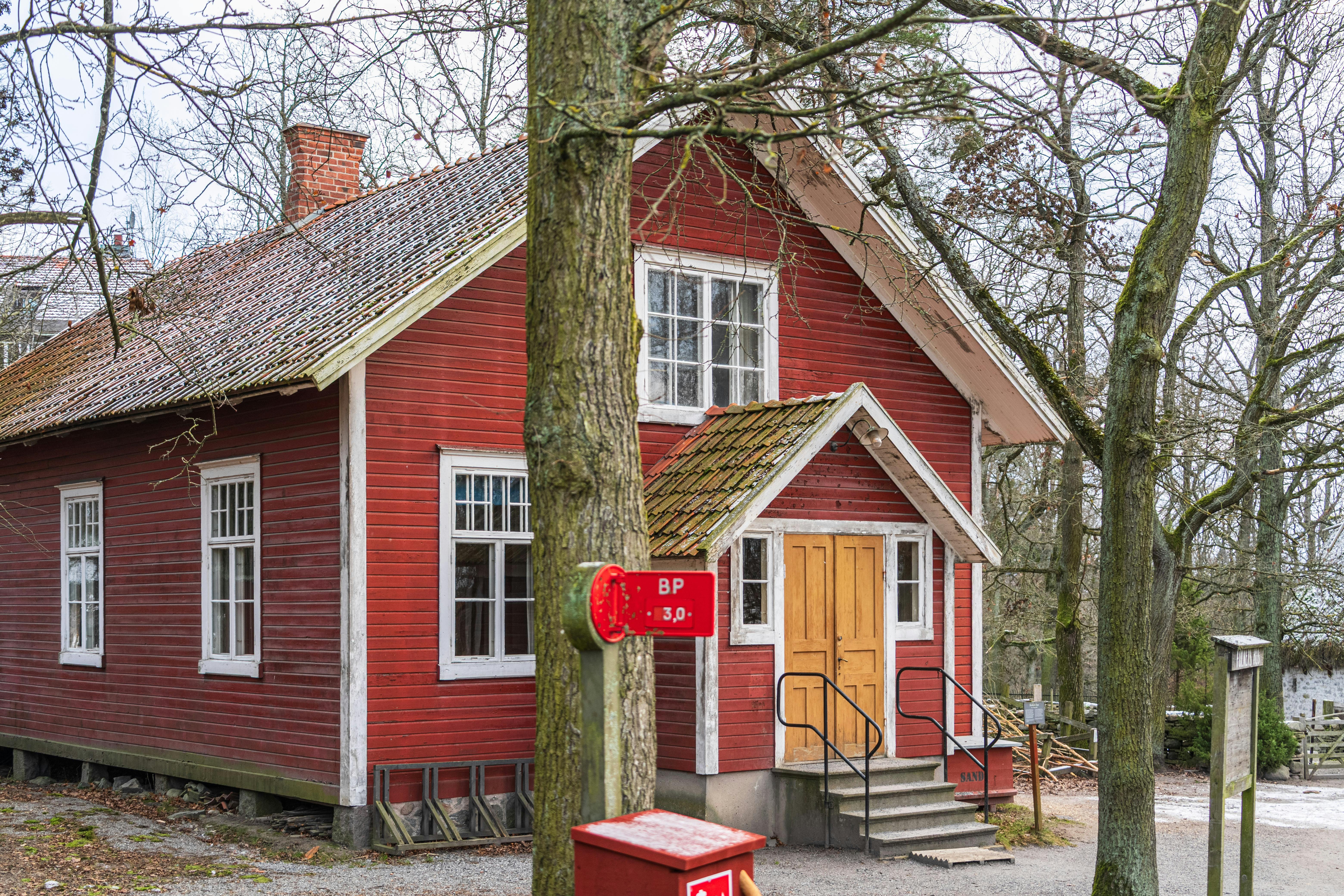 Explore this traditional red wooden house nestled in a snowy open-air museum in Stockholm, Sweden.