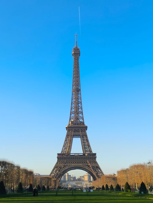 Free Eiffel Tower under blue sky, viewed from the Champ de Mars in Paris. A symbol of French elegance. Stock Photo
