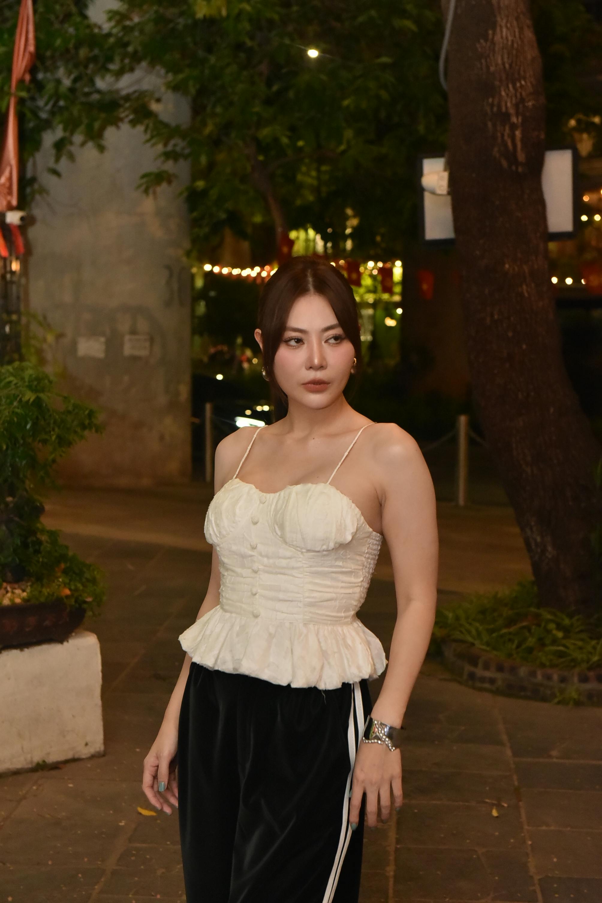 grátis Jovem mulher com roupa elegante posando ao ar livre à noite sob as luzes da cidade. Foto profissional