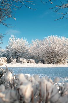 A serene winter scene of a snow-covered football goal in a sunny landscape.