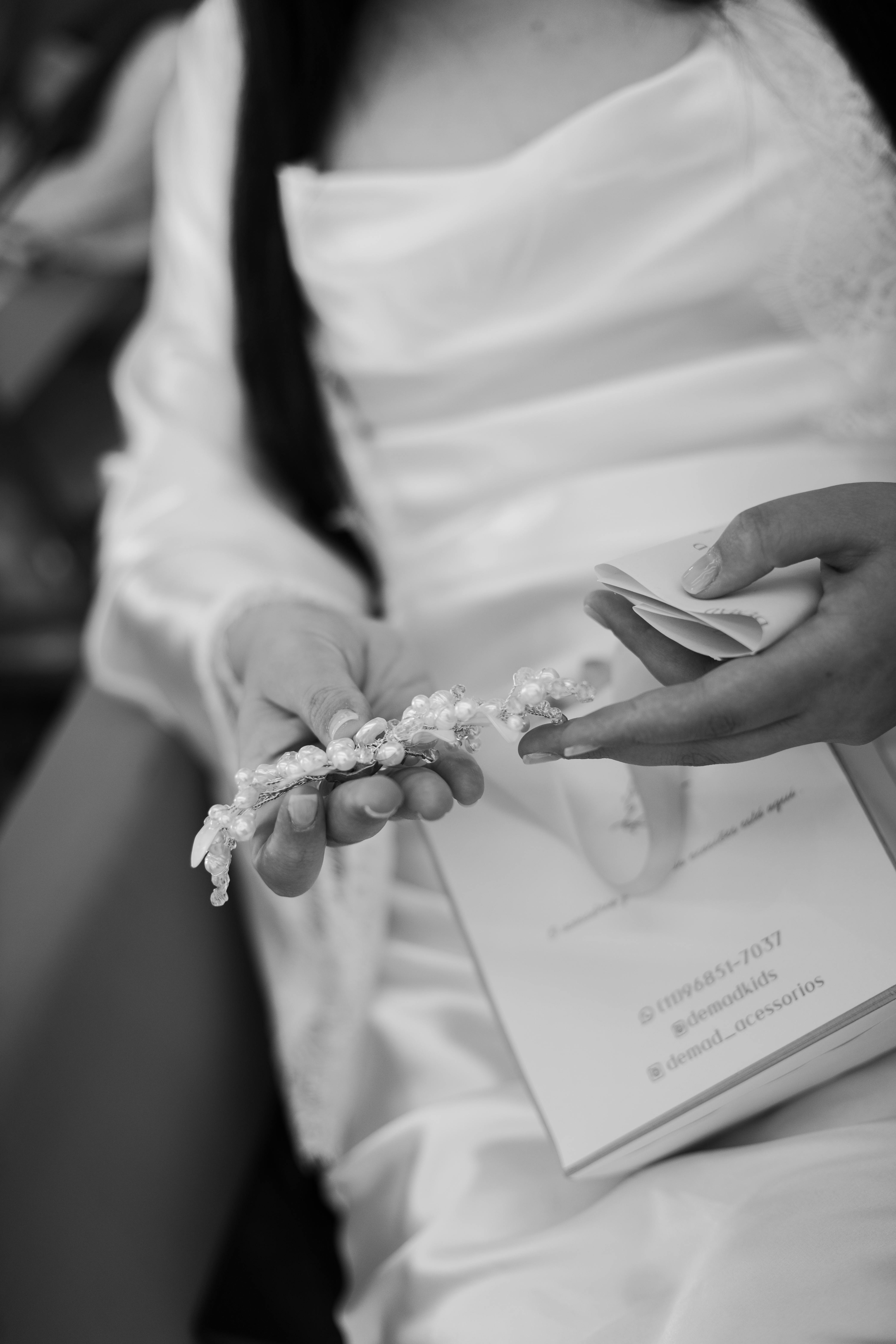 Gratis Primo piano di una sposa a San Paolo che tiene elegantemente in mano i dettagli delle nozze in stile monocromatico. Foto a disposizione