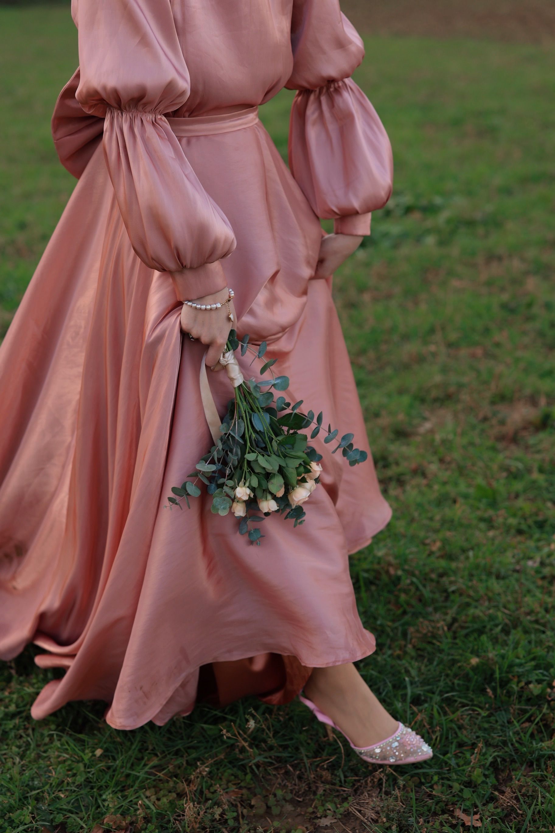 Elegant Woman in Pink Dress Holding Flowers Outdoors · Free Stock Photo