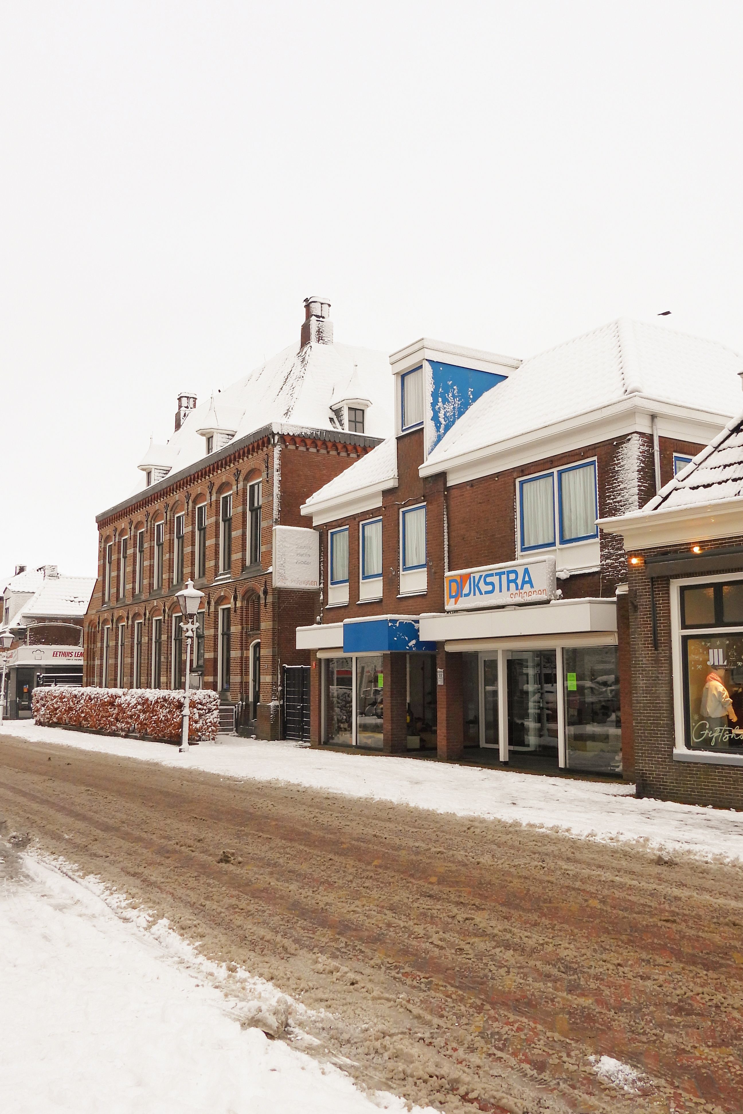 A serene European street scene with snow-covered buildings and wintery atmosphere.