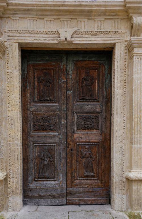 Free Close-up of an ornate carved wooden door set in a classical stone frame, exemplifying historic Italian architecture. Stock Photo