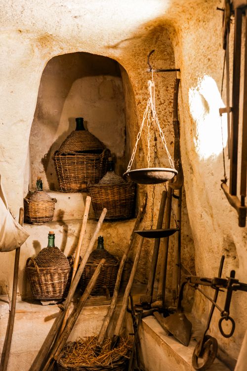 Free Explore a traditional Italian cave cellar with vintage wicker wine bottles. Stock Photo
