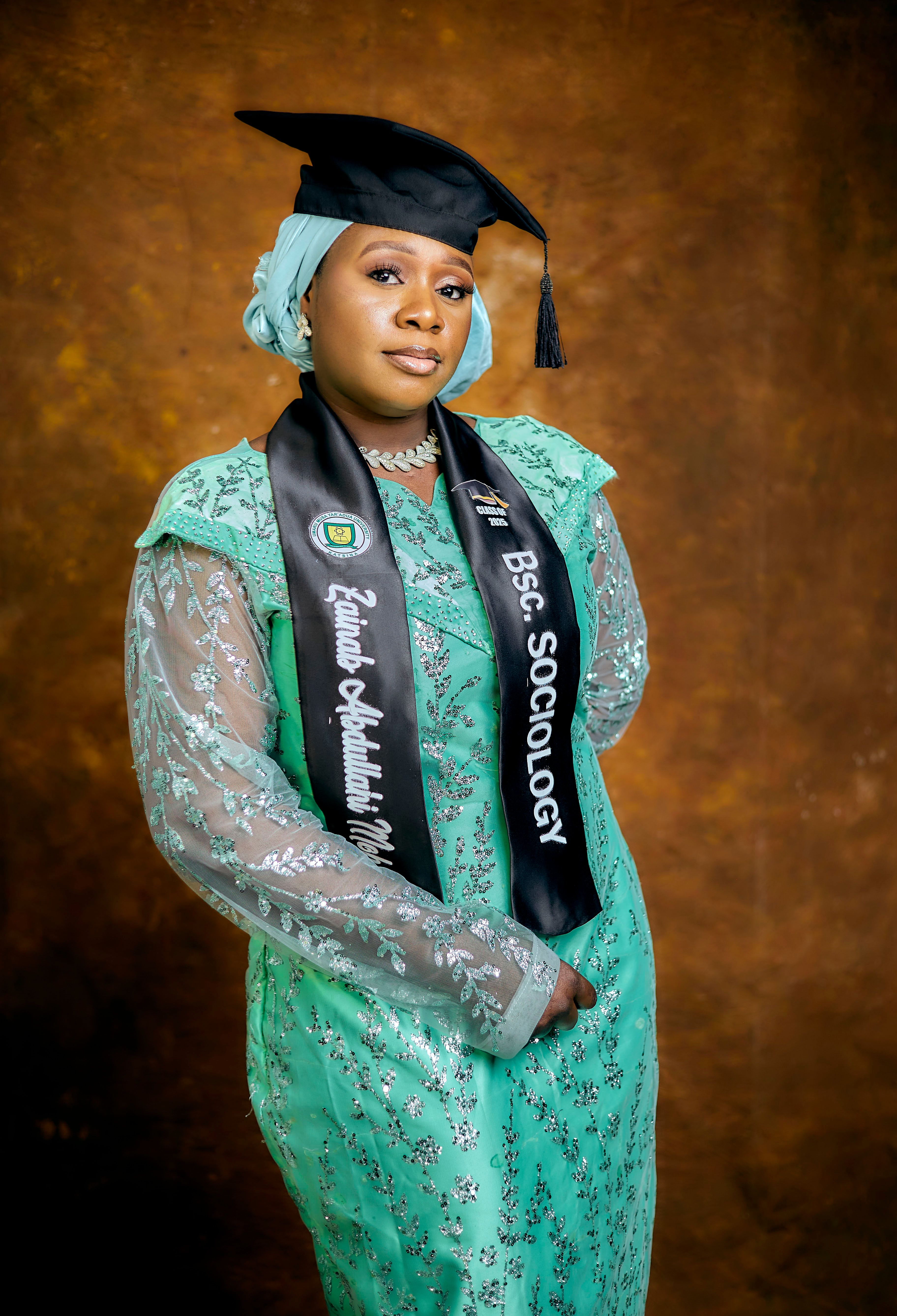 Proud female graduate in cap and gown celebrating achievement.