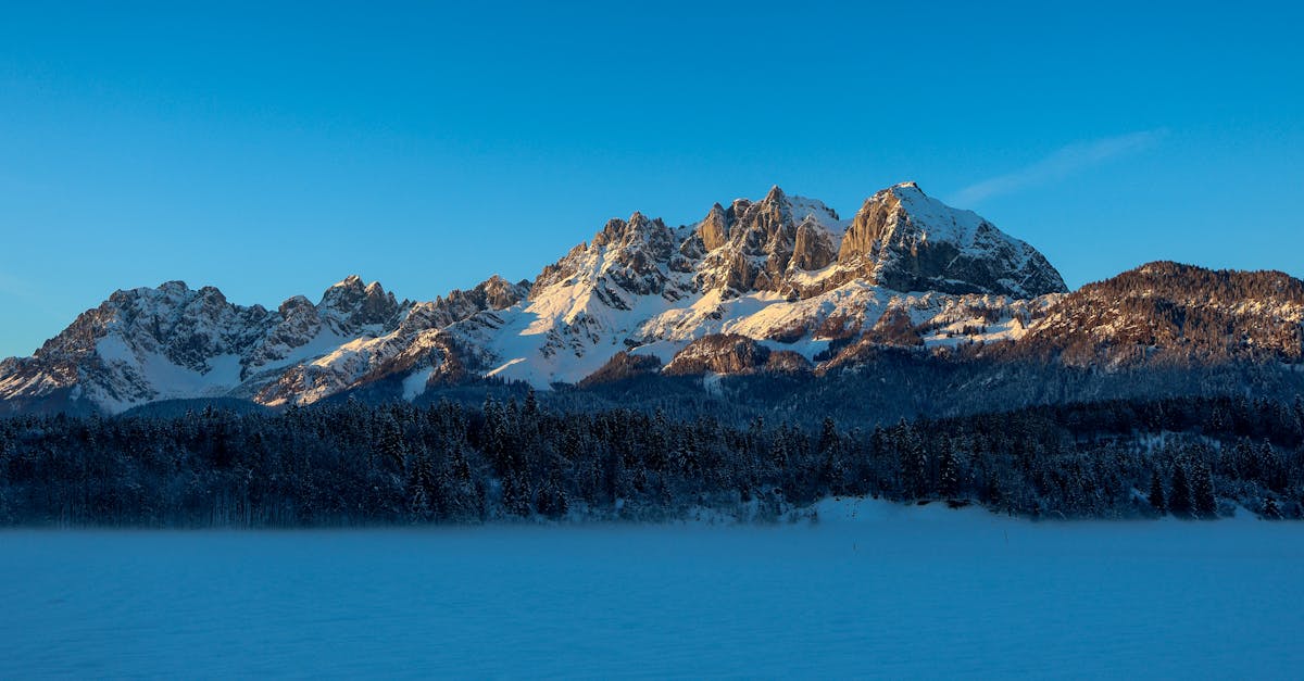 Stunning winter landscape of Wilder Kaiser mountains in Sankt Johann, Tirol with snowy peaks at sunrise.