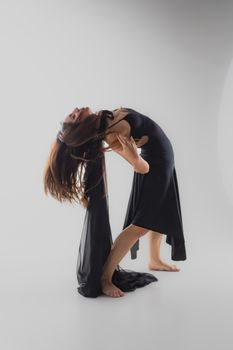 A ballerina in a fluid dance pose showcasing elegance and strength in a studio setting.