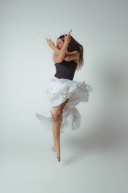 Free A female dancer captured mid-leap in a studio, showcasing grace and fluidity. Stock Photo