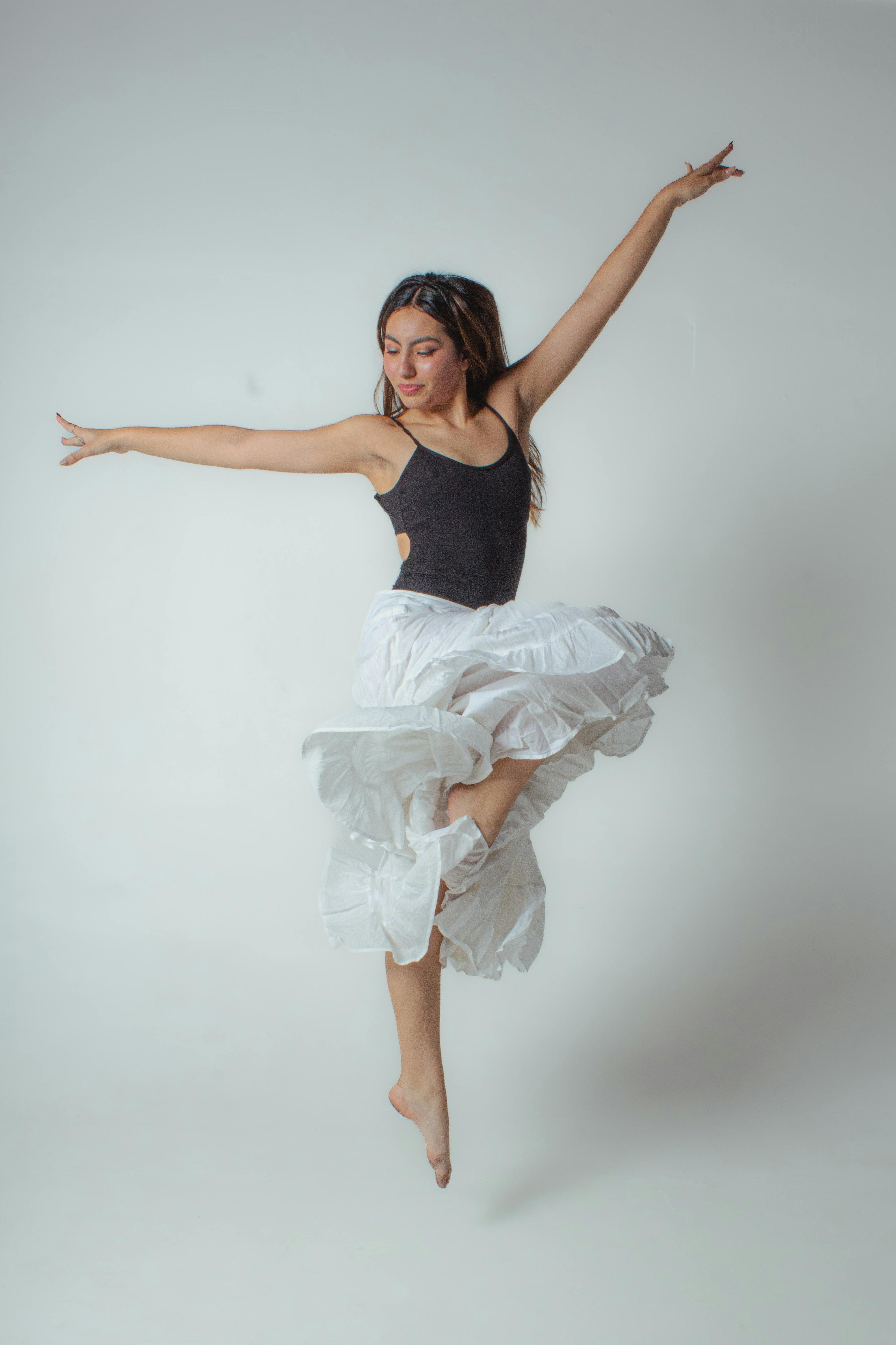 De franc Ballarina elegant en una postura a l'aire, que exuda força i elegància en una foto d'estudi. Foto d'estoc