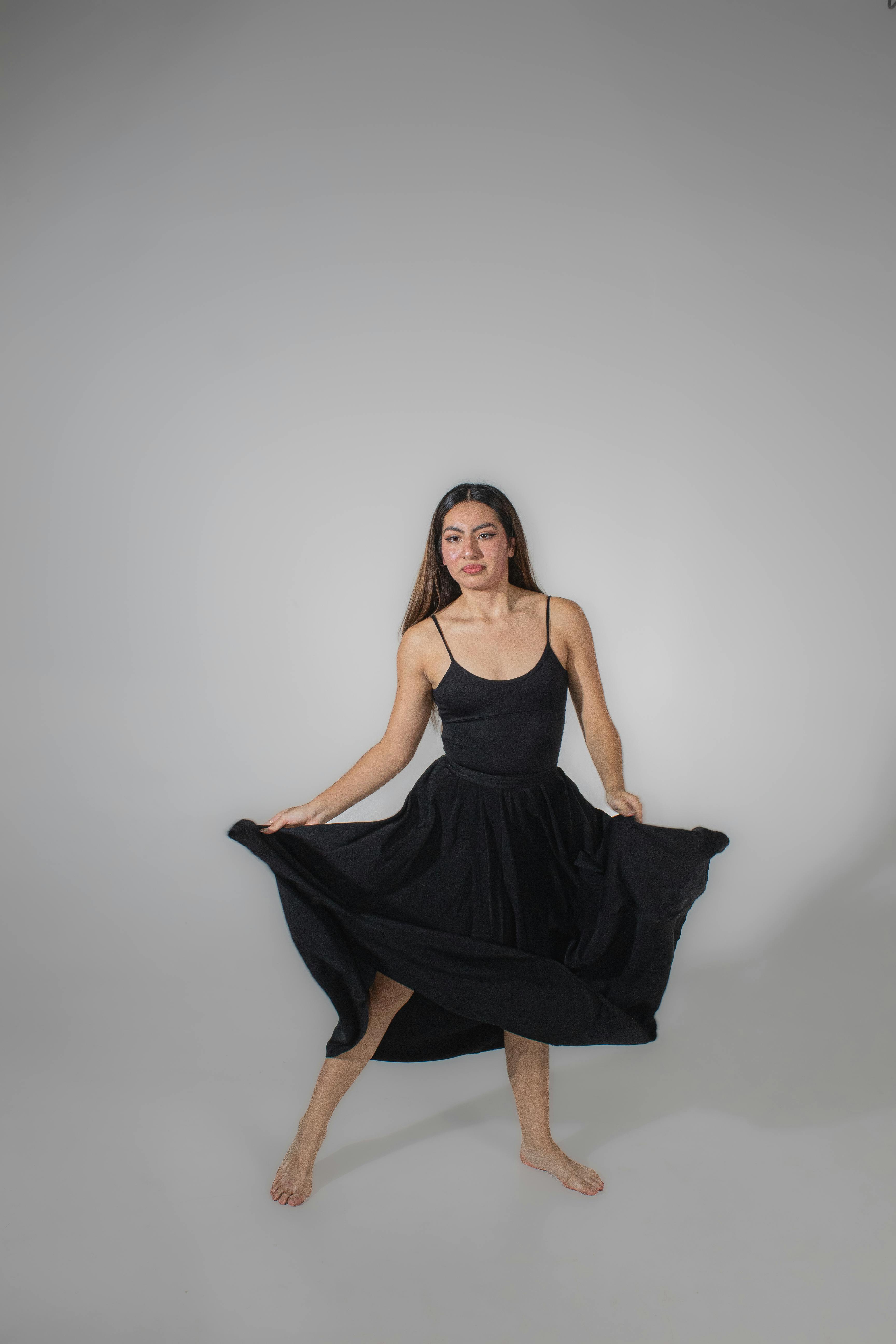 De franc Retrat d'estudi minimalista d'una ballarina amb un vestit negre posant amb gràcia. Foto d'estoc