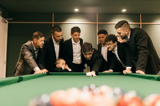 Uomini d'affari che giocano a biliardo e insegnano a un bambino in un vivace ambiente interno.