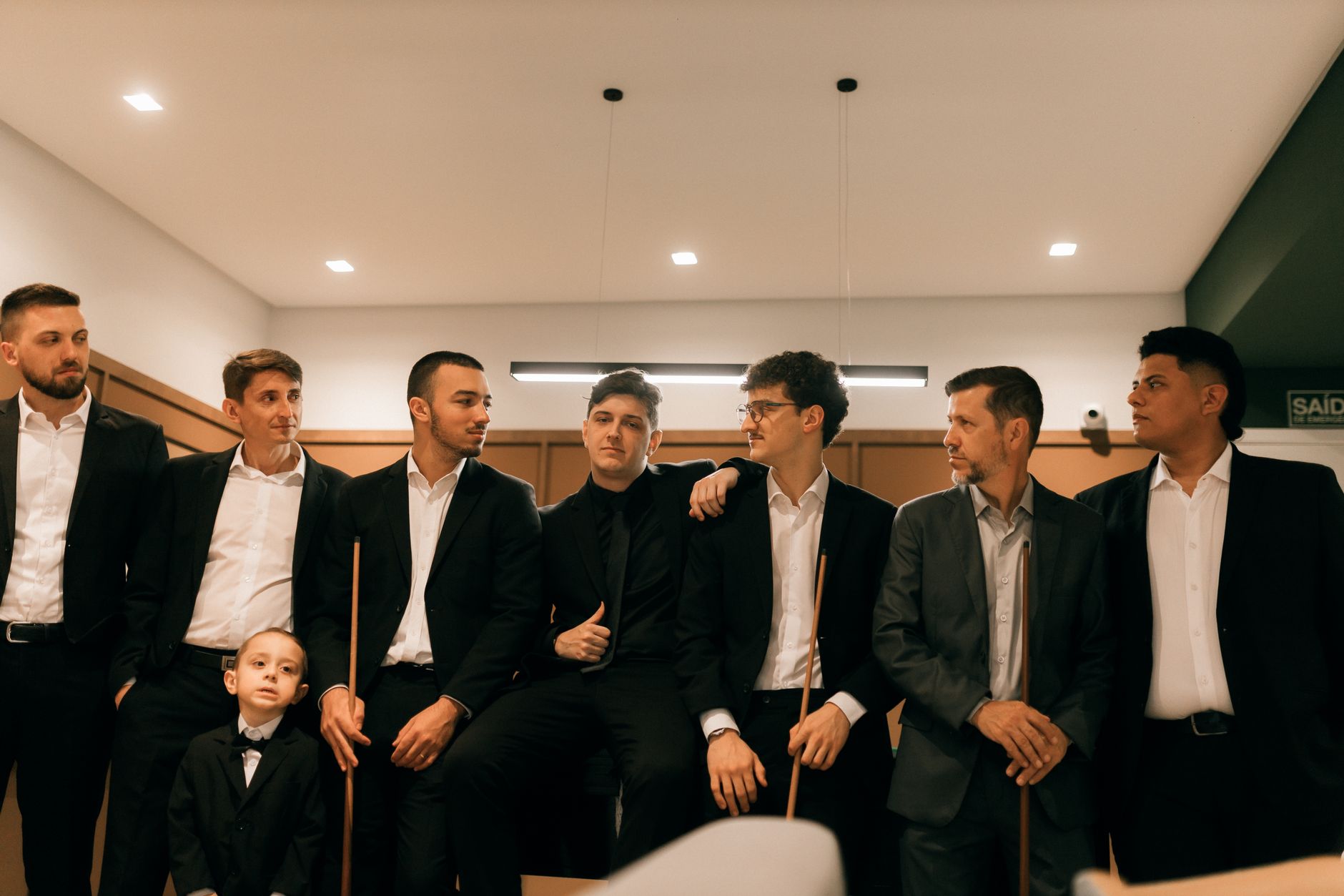 company funday activities cairo — A group of men and a boy in formal suits posing together indoors in a professional setting.