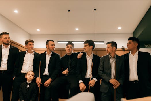 A group of men and a boy in formal suits posing together indoors in a professional setting.