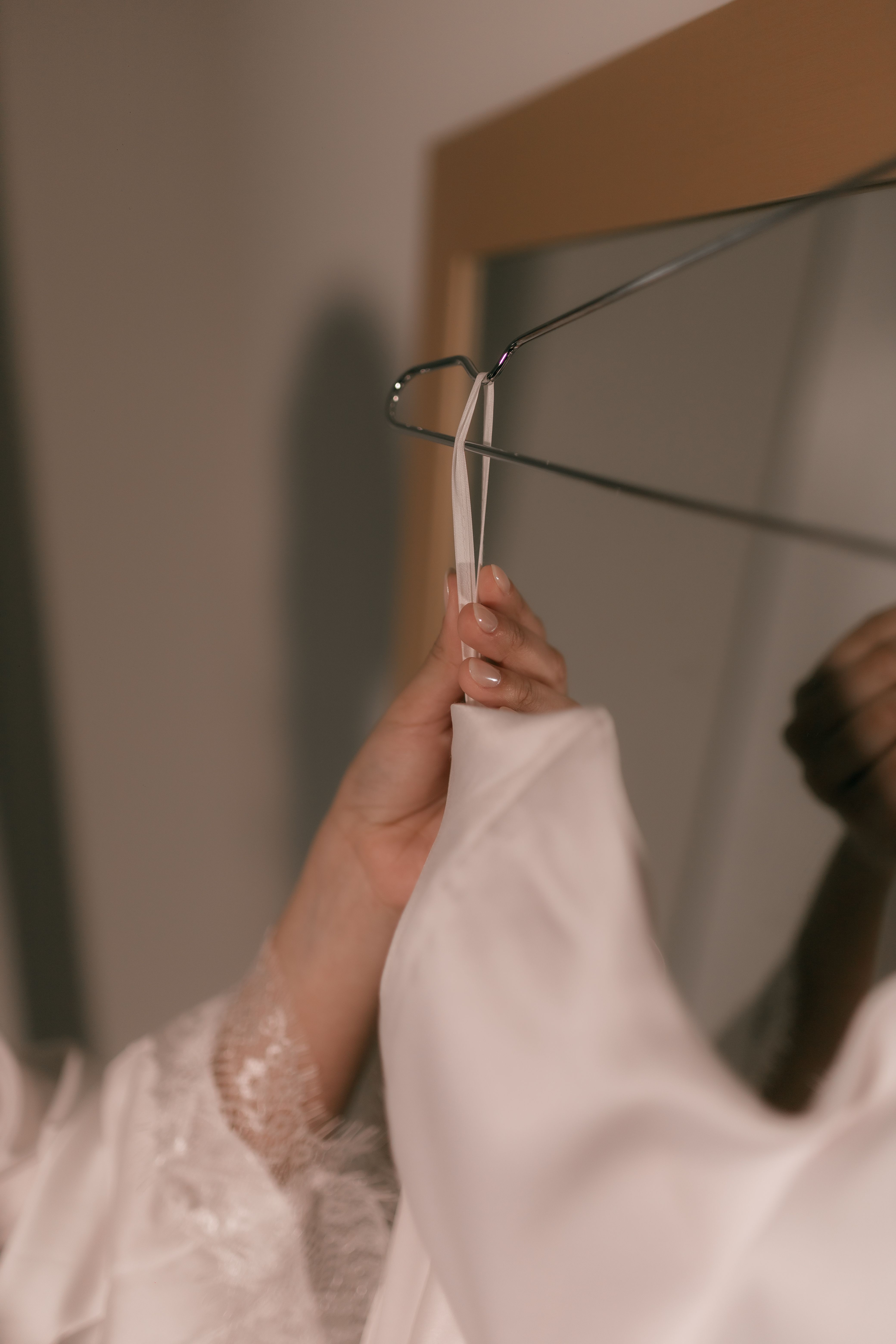 Hands hanging a white garment on a hanger — Alexander Mass on Pexels