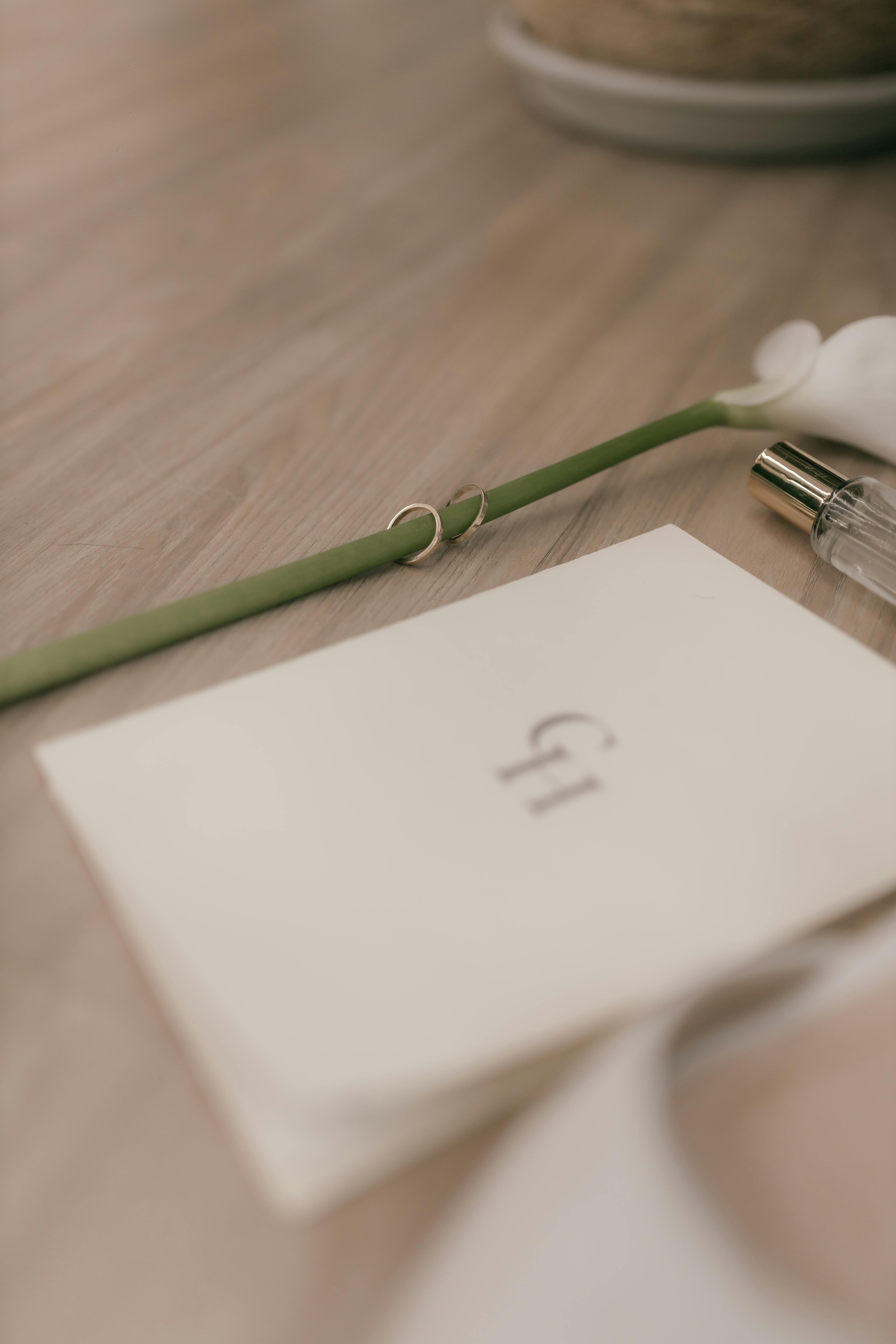 De franc Disposició plana i suau d'accessoris de casament amb anells i una sola flor sobre una superfície de fusta. Foto d'estoc