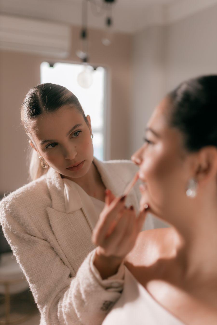 Professional makeup artist applying lipstick to a bride