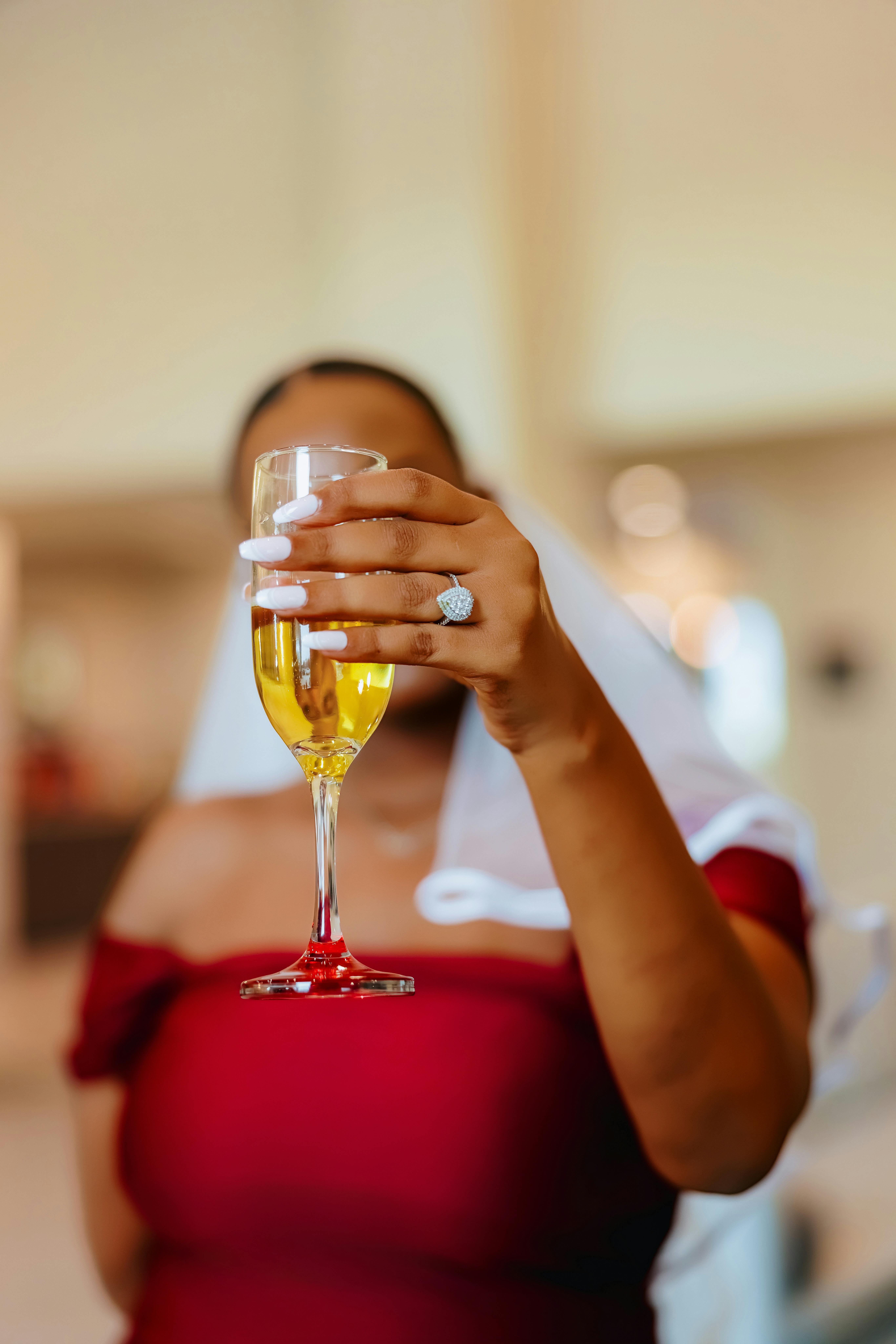 Gratis Kvinne i rød kjole som holder et champagneglass under feiring innendørs. Arkivbilde