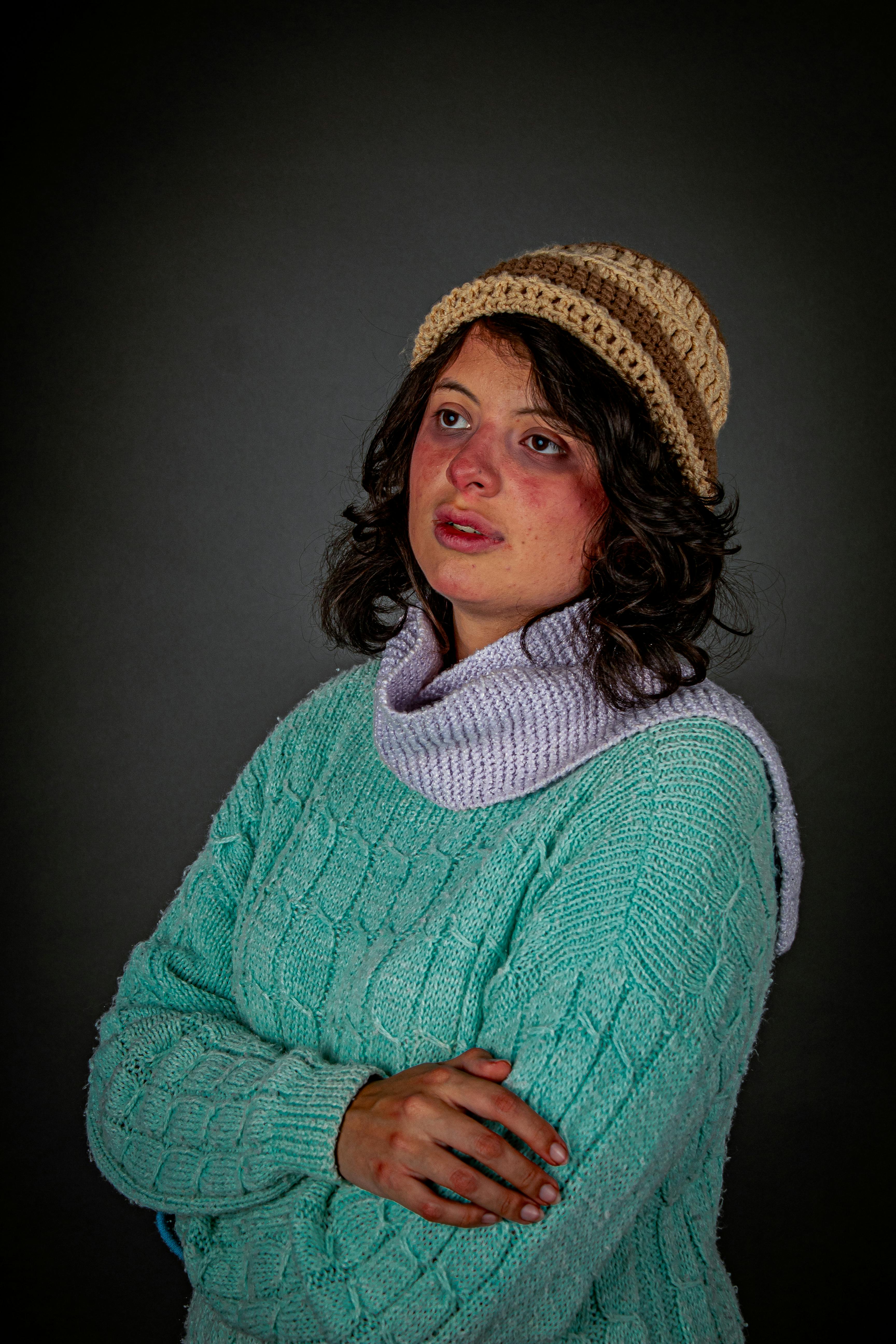 De franc Dona amb roba d'hivern amb aspecte pensatiu, amb un barret i un jersei de punt. Foto d'estoc