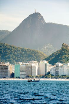 Stunning capture of Christ the Redeemer with Copacabana beach foreground and lush mountains.