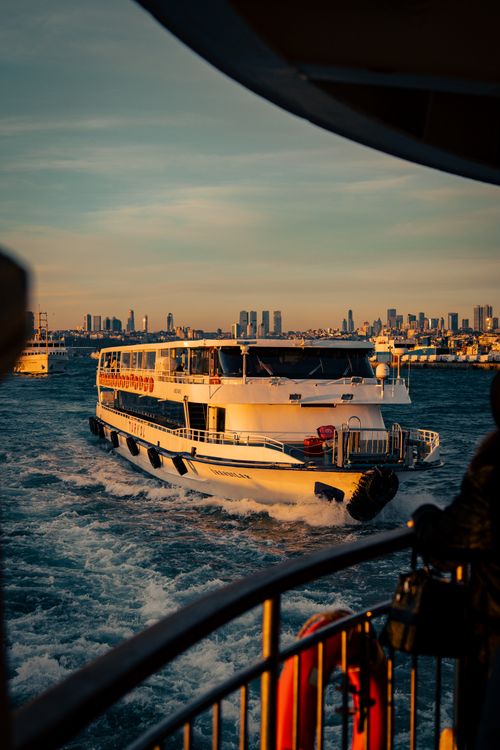 Free Ferry navigating the Bosphorus Strait at sunset with Istanbul's skyline in view. Stock Photo