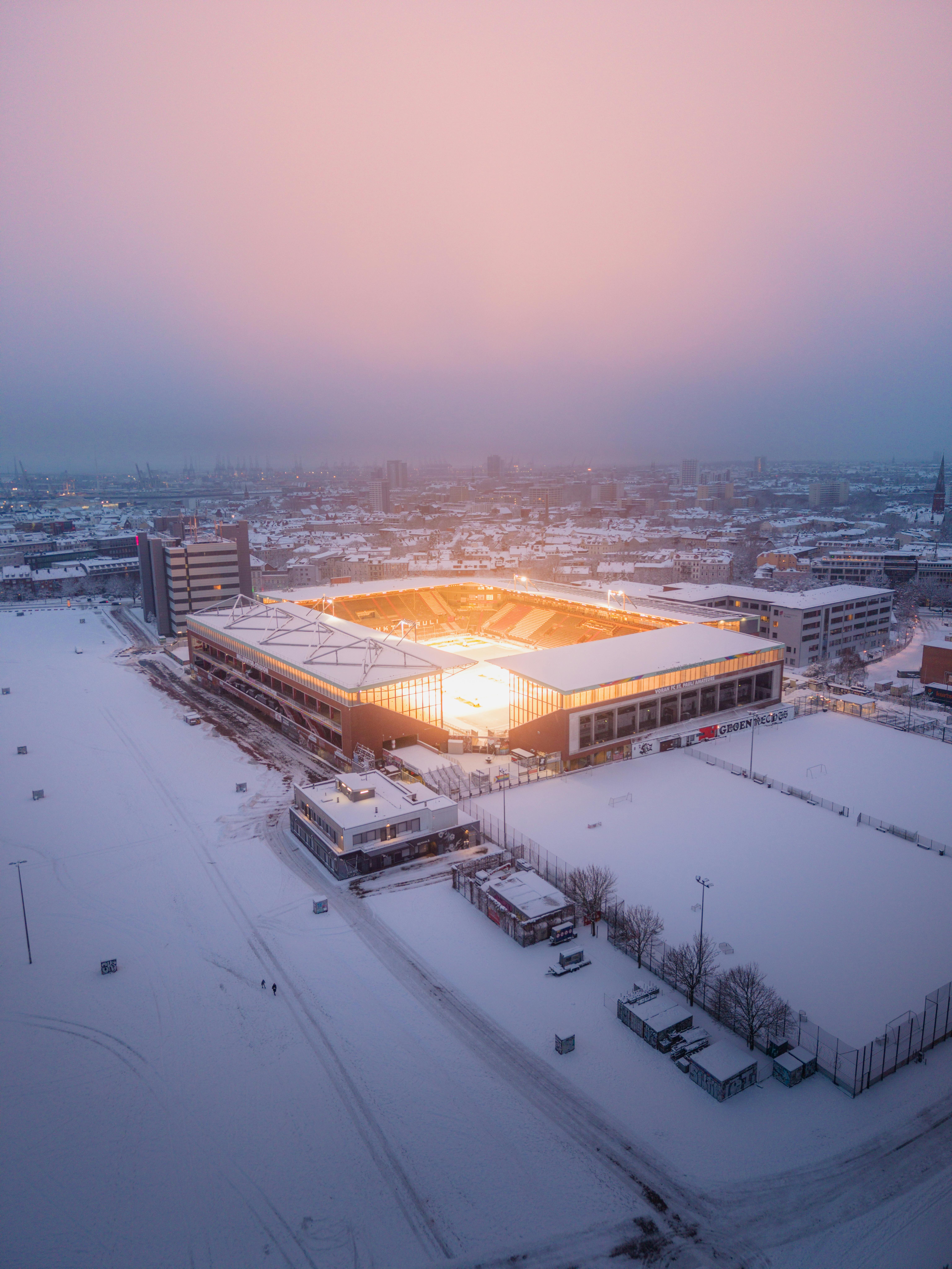 Ücretsiz Gün batımında karlı Hamburg'da ışıl ışıl parlayan bir stadyumun nefes kesen kuşbakışı görüntüsü. Stok Fotoğraflar