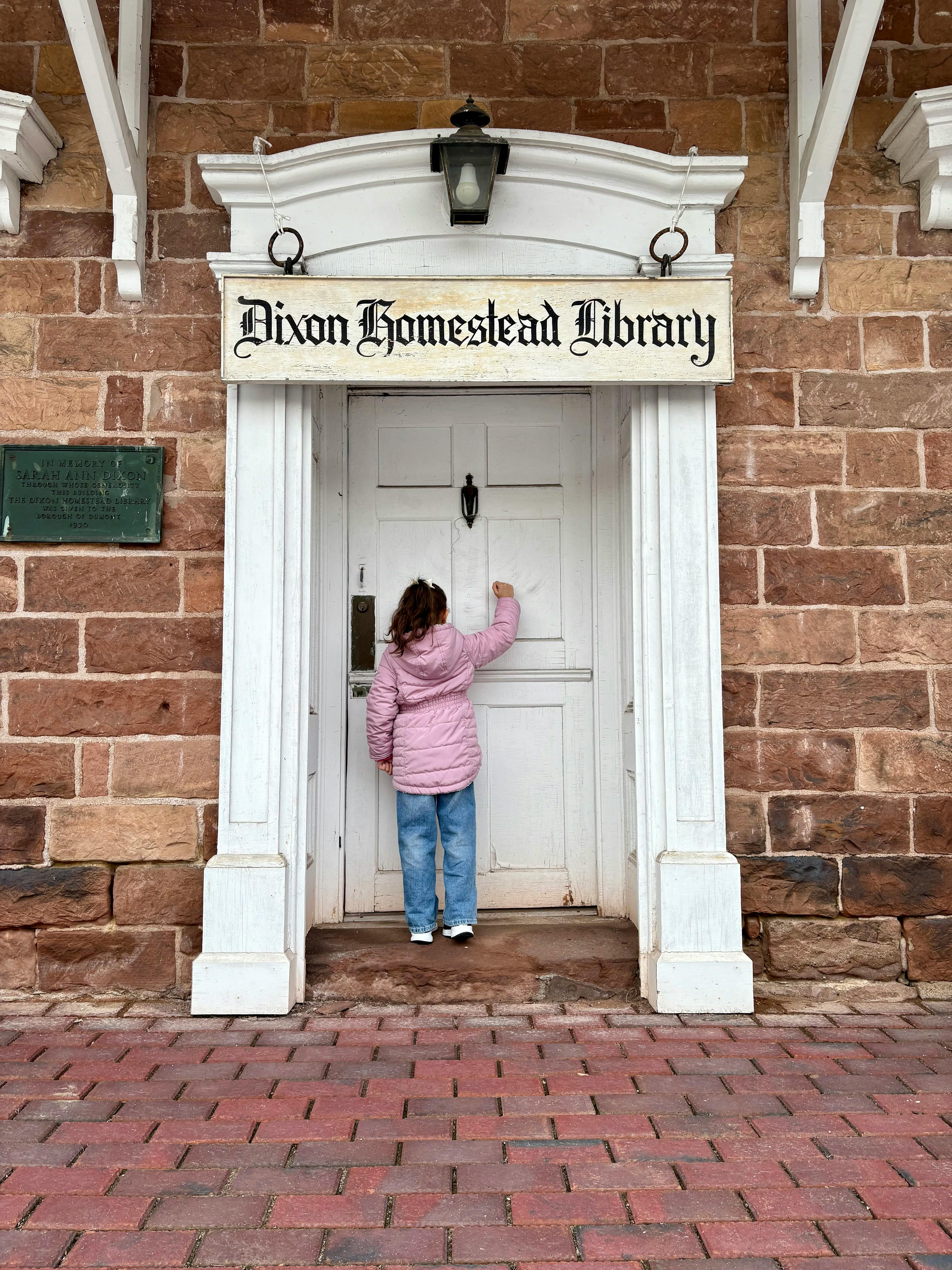 Child Knocking at Historic Library Door in Dumont · Free Stock Photo
