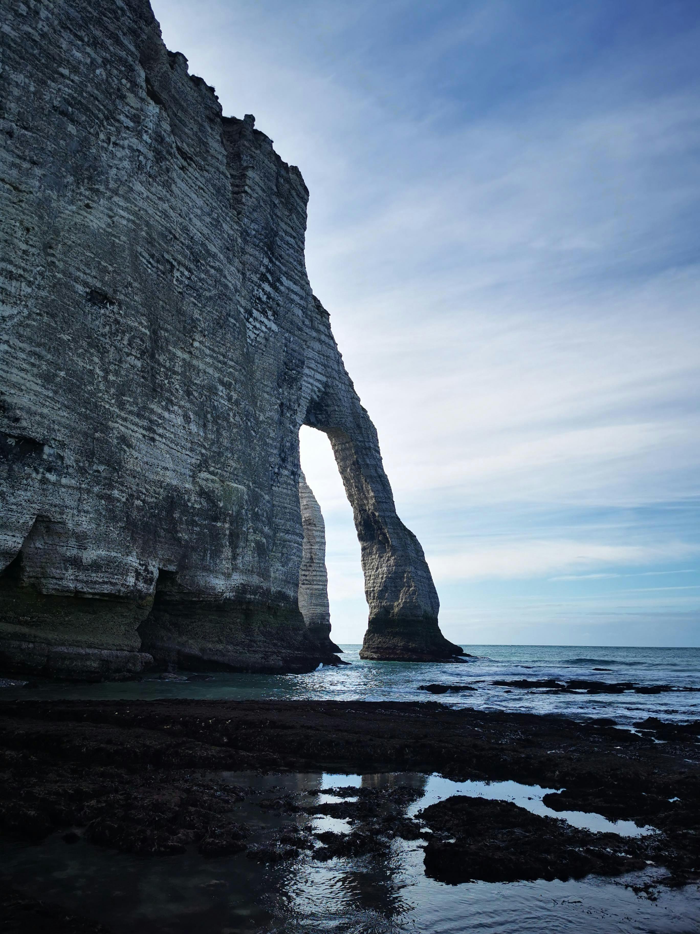 Scenic view of the iconic cliffs of Étretat, France, with natural arch and serene ocean landscape.