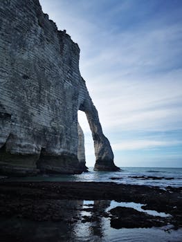 Scenic view of the iconic cliffs of Étretat, France, with natural arch and serene ocean landscape.