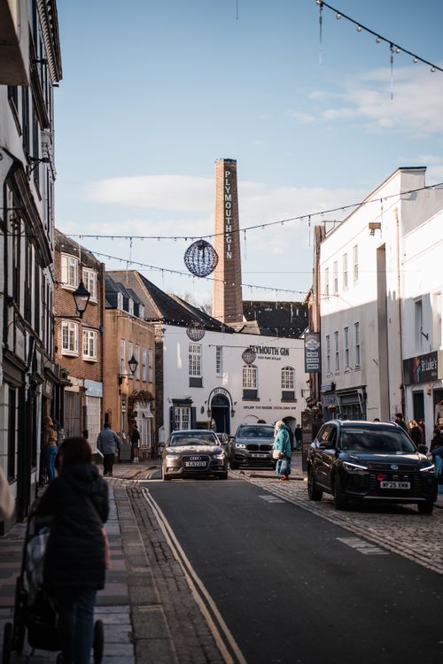 Free Plymouth street view with Plymouth Gin Distillery and people enjoying a sunny day in England. Stock Photo