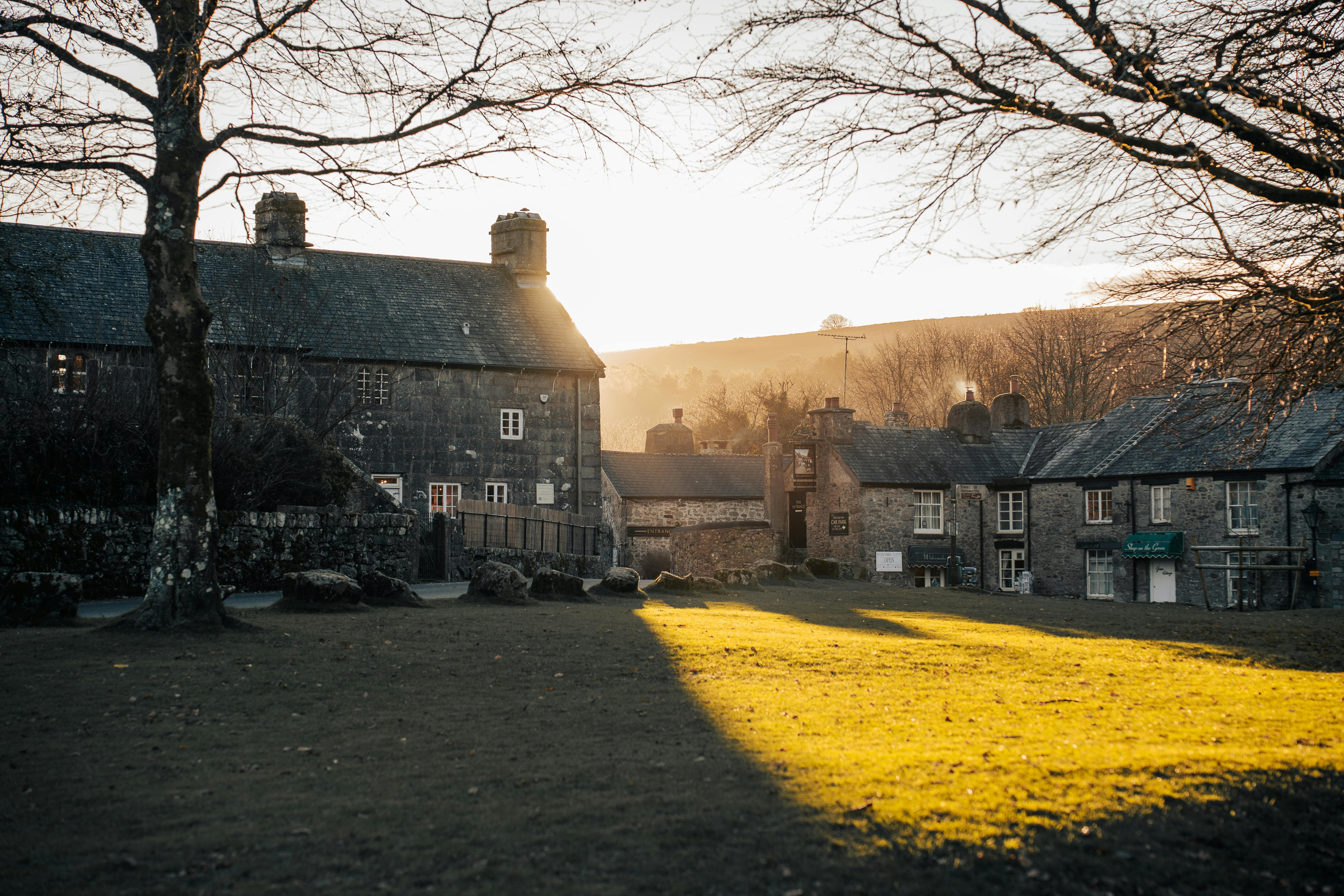 Morning light over historical buildings in Widecombe-in-the-Moor, capturing serene rural England.
