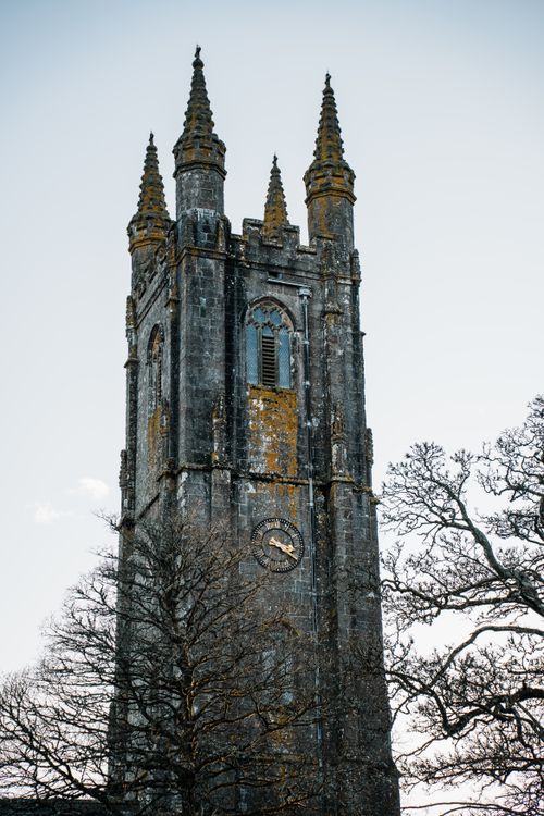 Free Scenic view of St Pancras Church tower surrounded by bare trees in Widecombe-in-the-Moor, England. Stock Photo