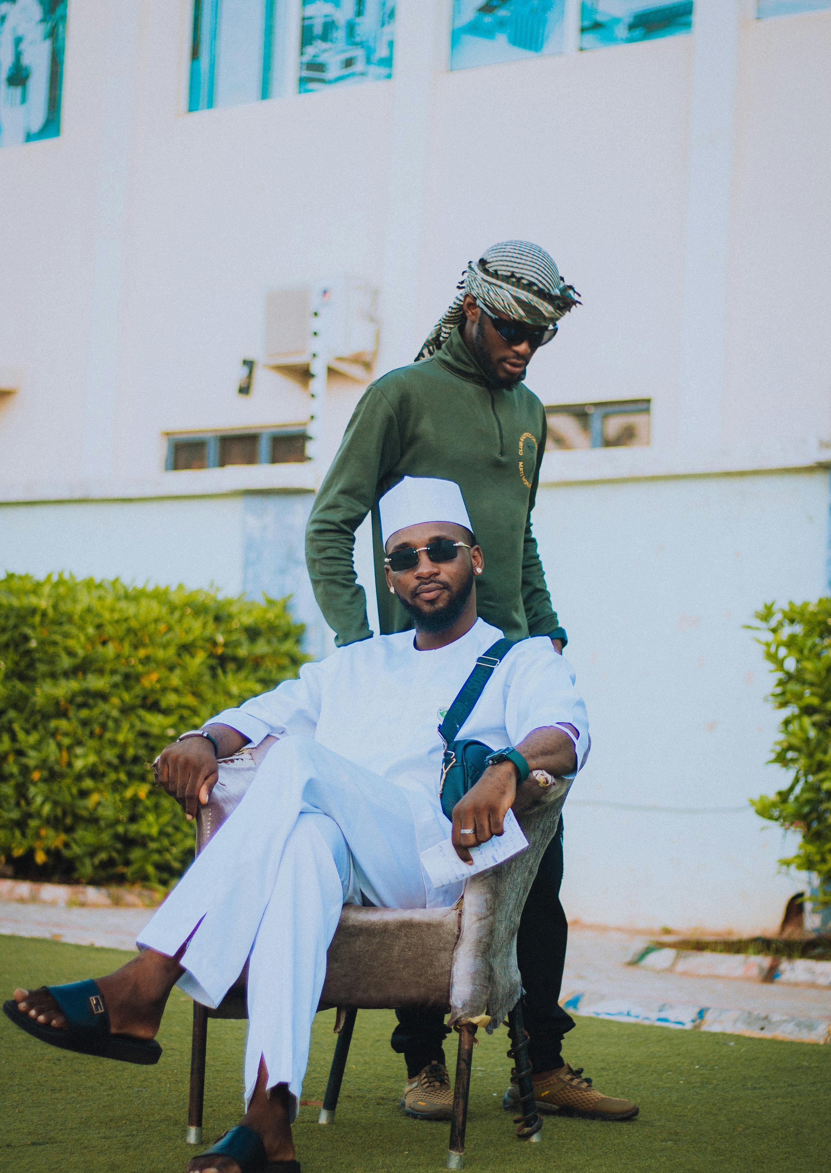 De franc Dos homes amb roba tradicional posen amb confiança a l'aire lliure, mostrant un estil cultural. Foto d'estoc