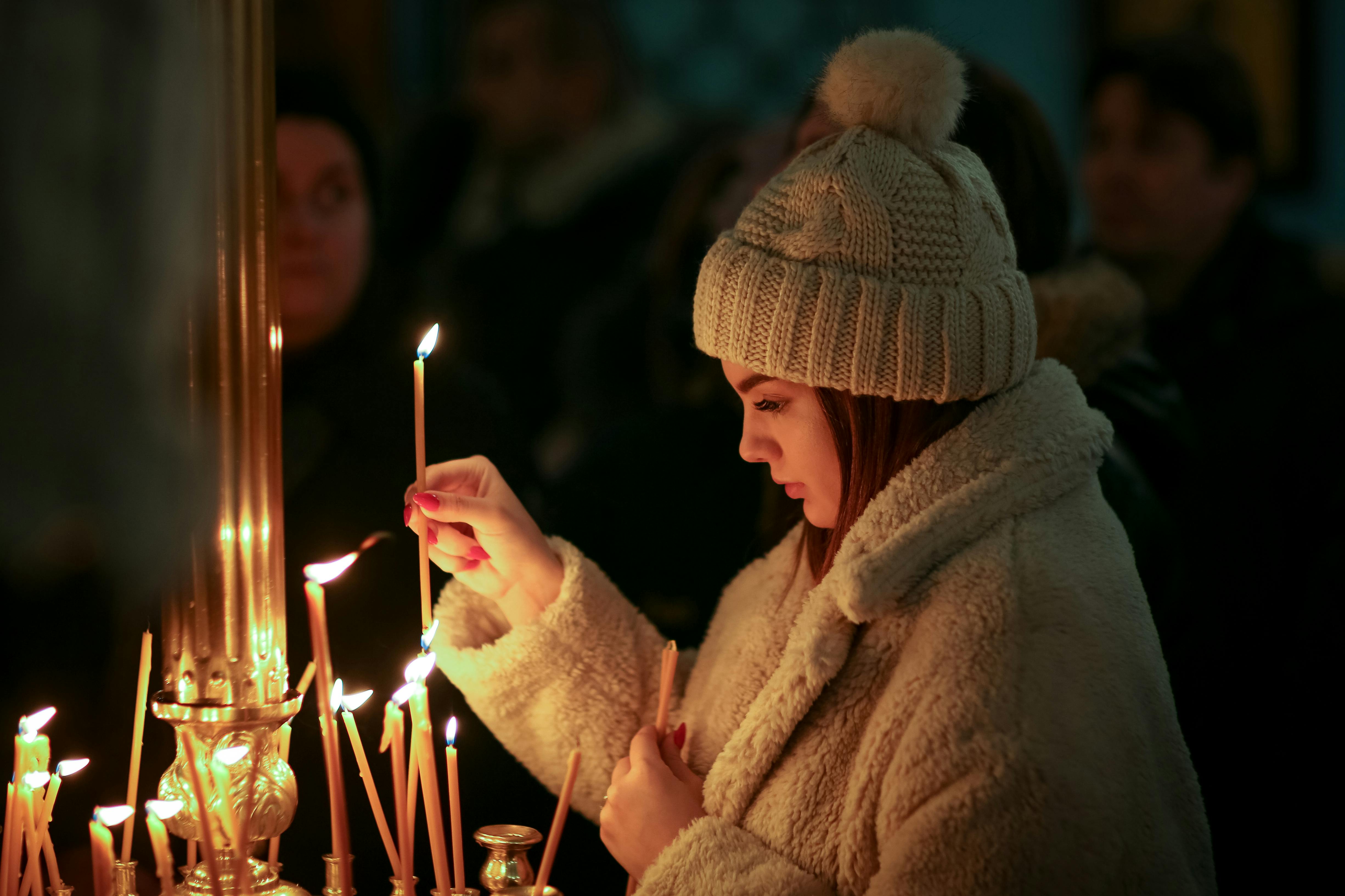 Woman in Brown Fur Coat and Cap Holding Lighted Candles · Free Stock Photo