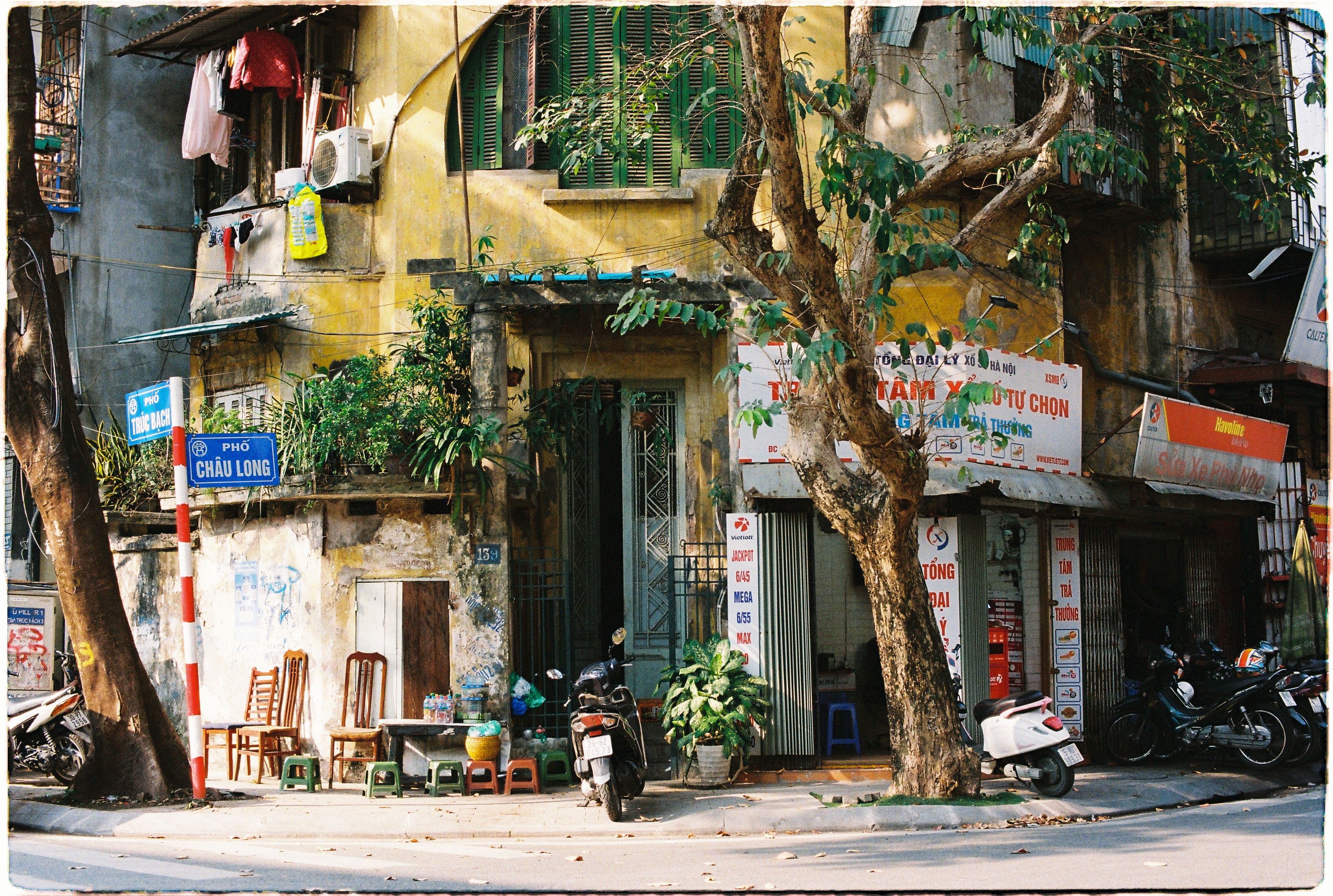 Vintage Hanoi street view featuring a rustic building and motorbikes.