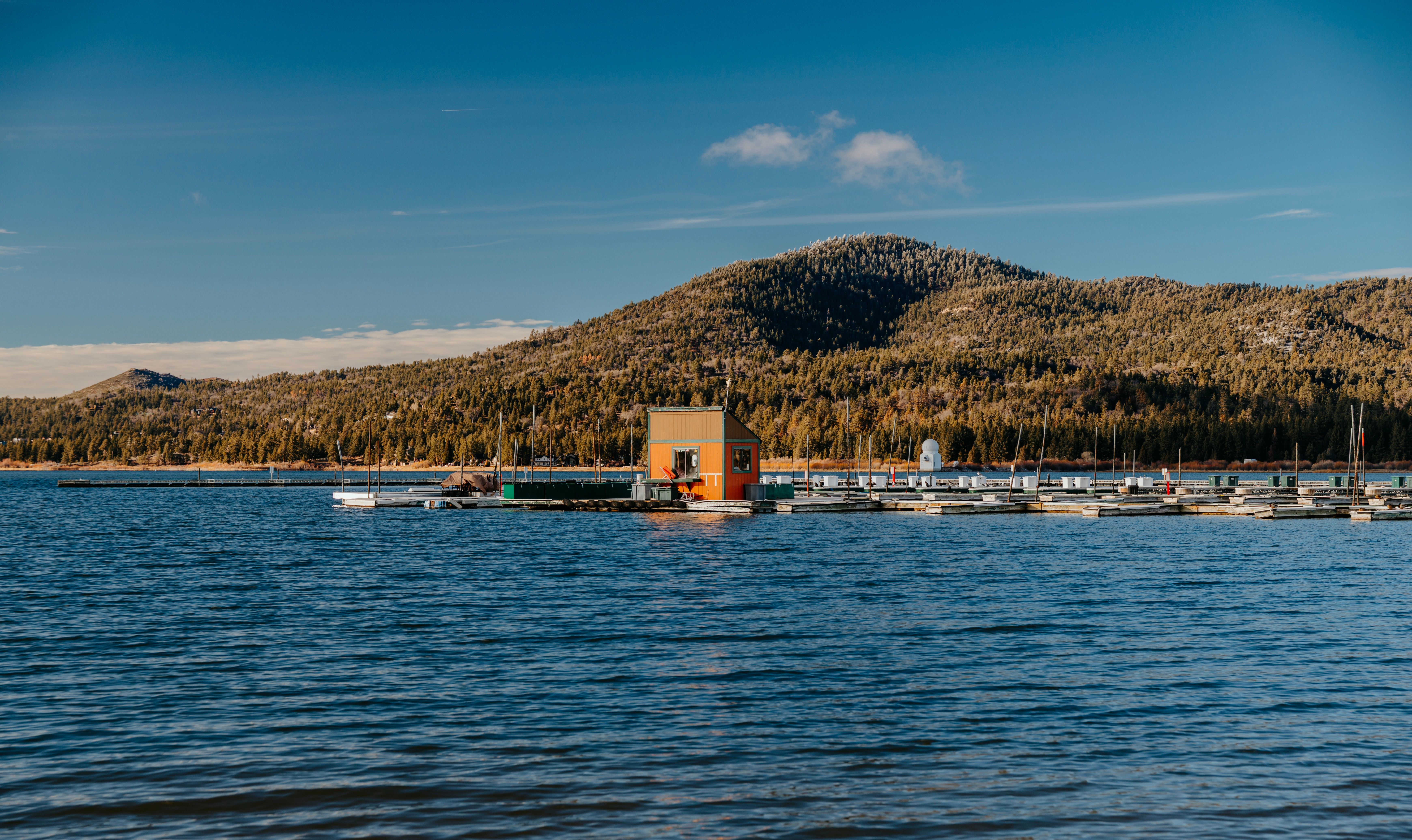 Scenic view of a tranquil lake with a dock and mountain backdrop.