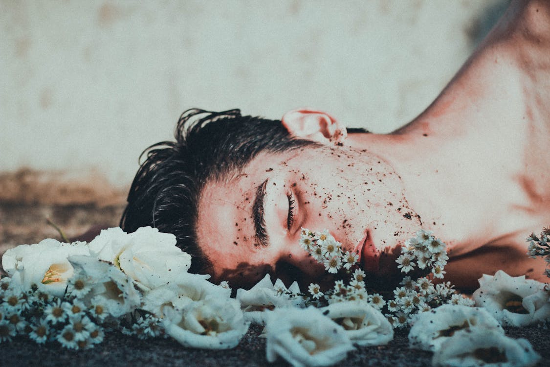 Free Man Lying on White Flowers Stock Photo