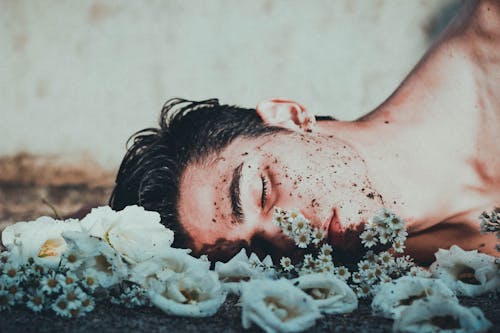 Free Man Lying on White Flowers Stock Photo
