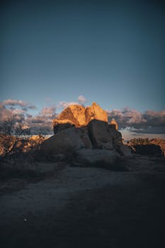 日落为偏远沙漠中崎岖的岩石地貌与戏剧性的天空增添了光彩