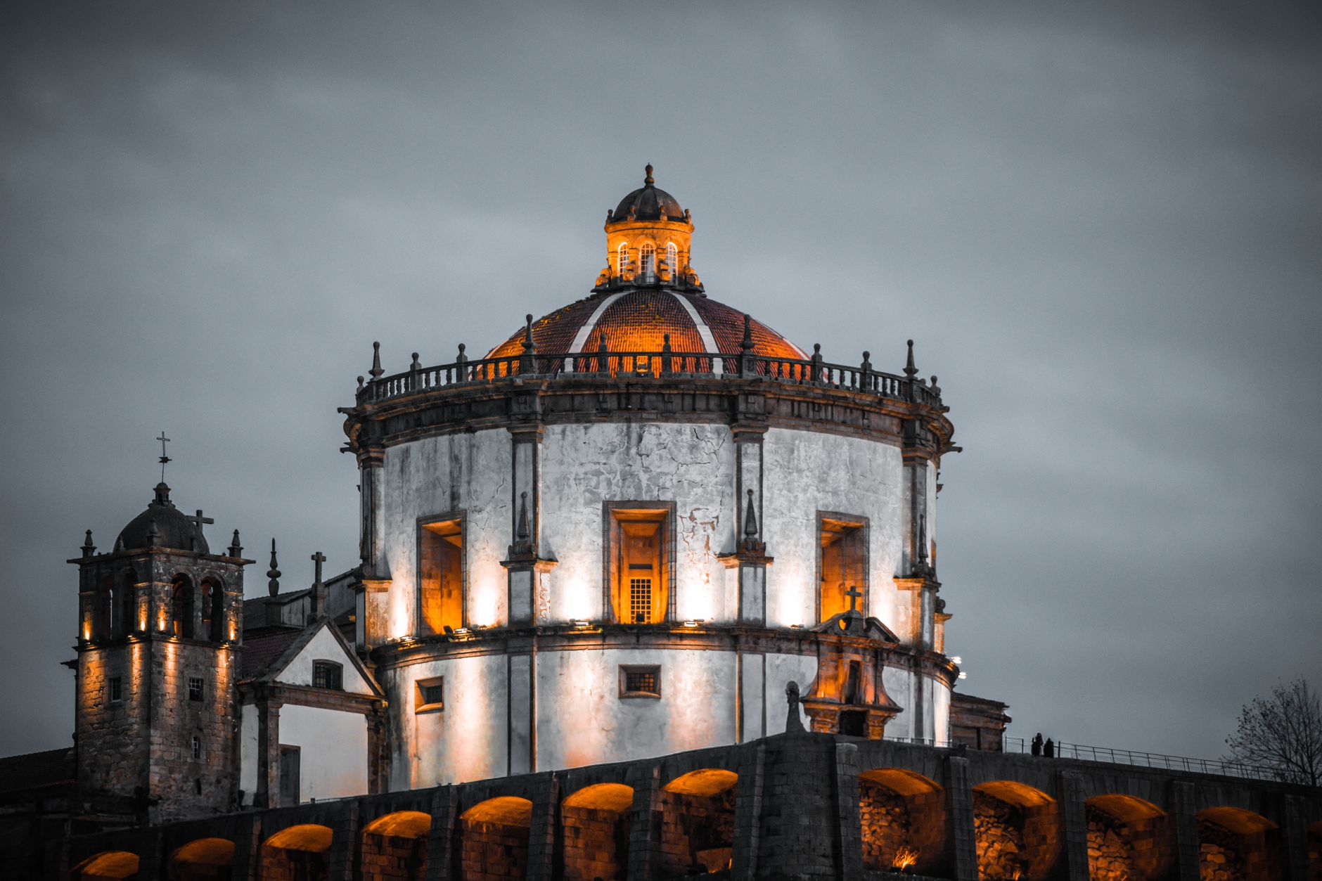 Stunning view of Serra do Pilar Monastery, Porto, with evening lights highlighting ancient architecture.