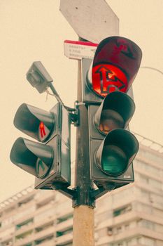 A vintage-style traffic light with visible buildings in the background, showcasing an urban environment.
